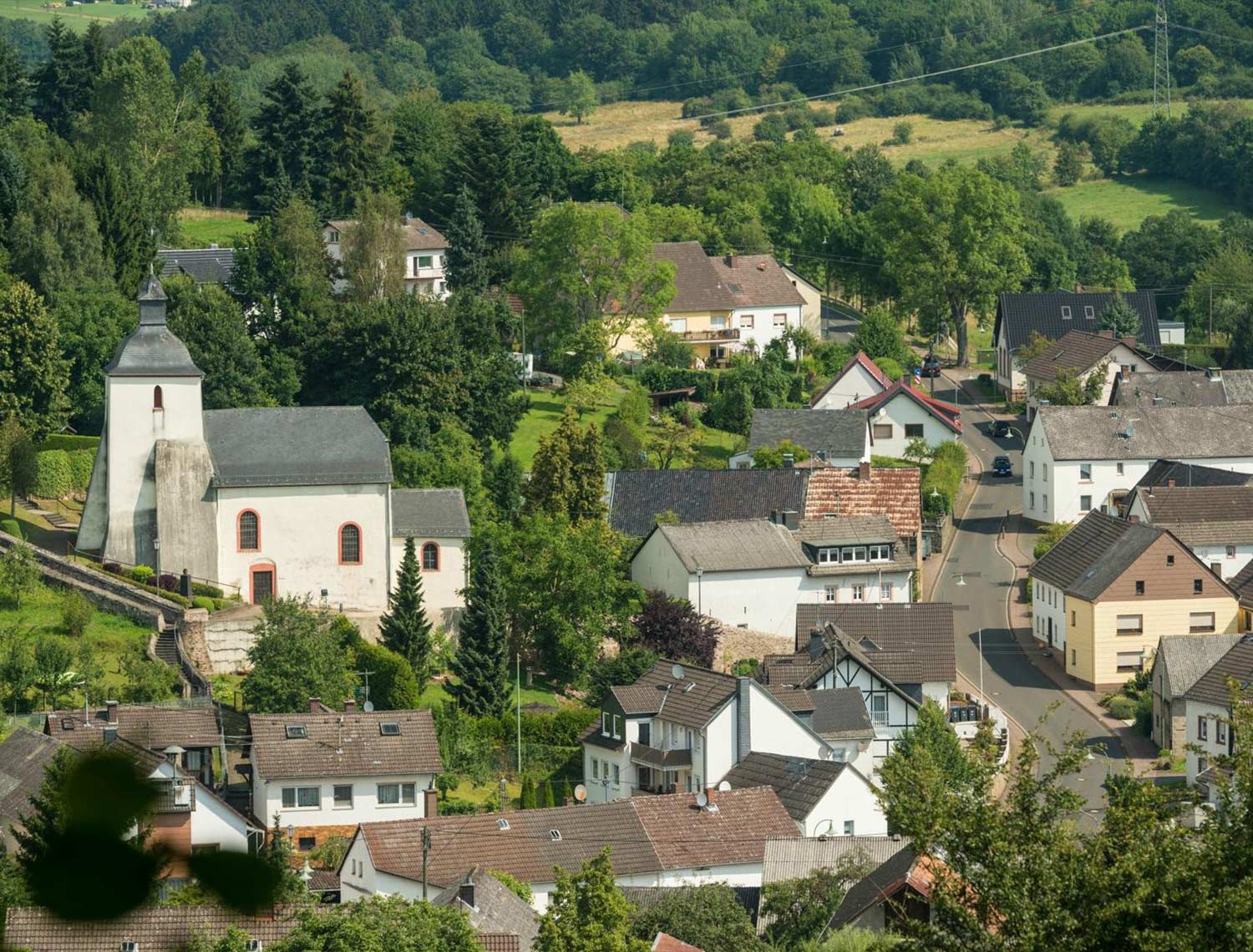 Hier sieht man eine Kleines Dorf mit einer Hauptstraße durchführend. Das Bild wurde von einem Hügel runter geschossen.